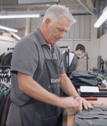 A man with a Barbour apron on working in a factory